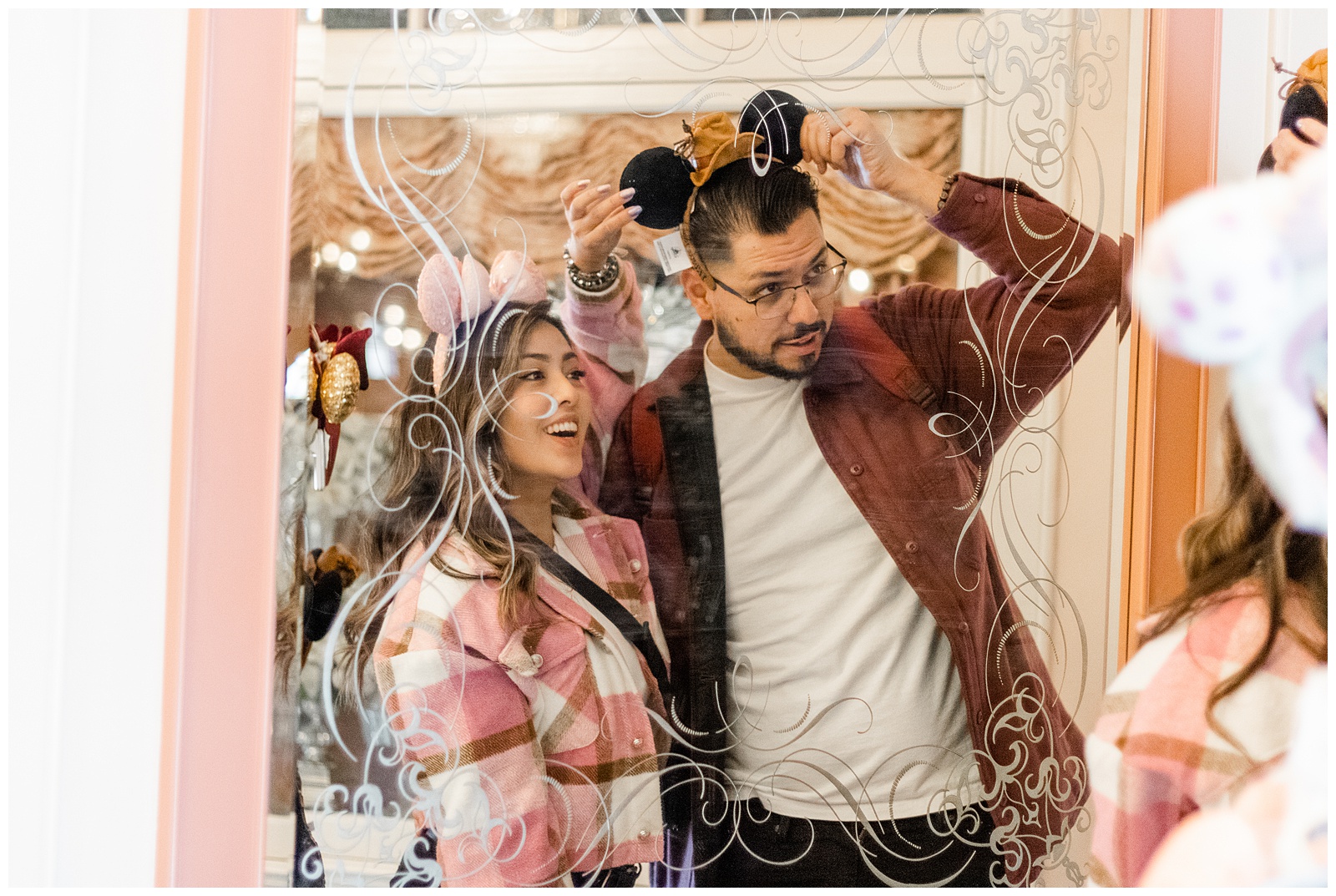 Smiling couple in front of the decorative Main Street Emporium mirrors at Disneyland