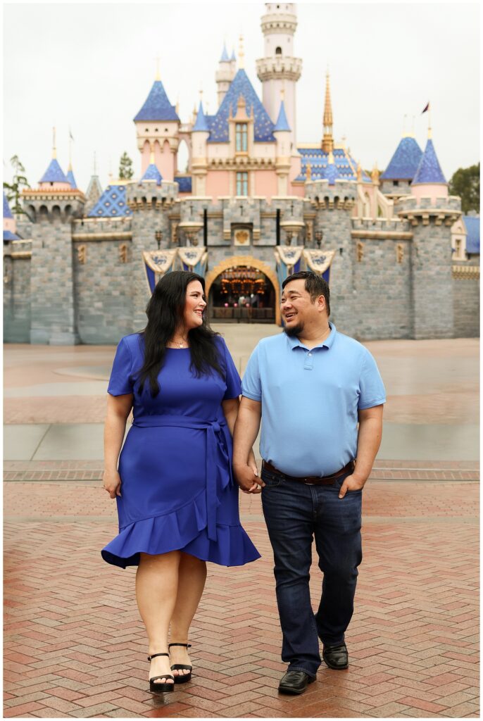 Couple posing in front of Sleeping Beauty Castle at Disneyland